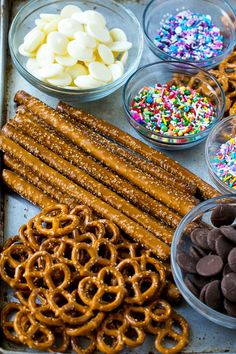 an assortment of pretzels, chocolate and marshmallows on a baking sheet