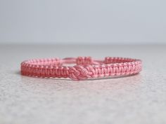 two pink bracelets sitting on top of a table