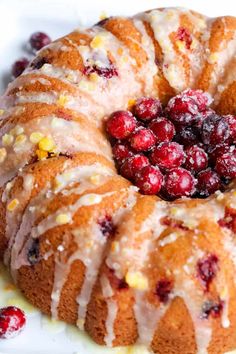 a cranberry orange bundt cake on a plate with lemon glaze and fresh cranberries