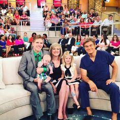 a family sitting on a couch in front of an audience