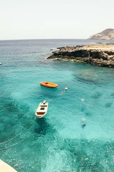 several small boats floating in clear blue water