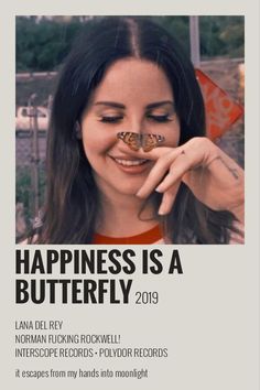 a woman holding a butterfly in front of her face with the caption happiness is a butterfly