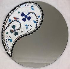 a circular mirror with a mosaic design on it