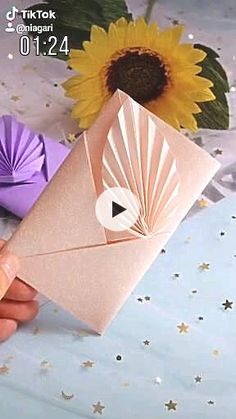 a person is holding an origami envelope