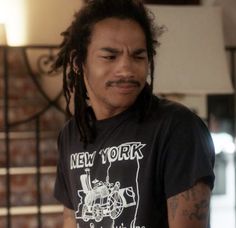 a man with dreadlocks and a new york t - shirt