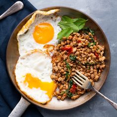 a plate with eggs, spinach and other food on it next to a fork