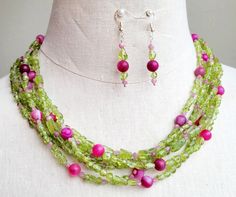 Strung with an assortment of polished and faceted lime green peridot stones, pink tourmaline stones, and round pink agate stone on six wires, this necklace is finished with decorative bead caps and a lobster clasp.  Necklace measures 20 inches long. Matching beaded earrings are hung on 925 silver ear wires. Green Beaded Necklace, Peridot Stone, Pink Agate, Tourmaline Stone, Necklace And Earrings Set, Green Peridot, Agate Necklace, Green Necklace, Bead Jewellery