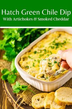 a hand holding a spoon full of green chile dip with artichokes and smoked cheddar