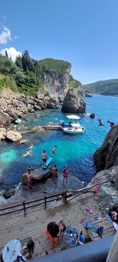 people are standing on the rocks near the water