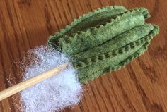 a pair of knitting needles resting next to a pile of yarn on a wooden table