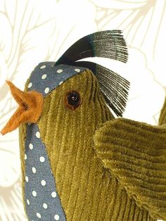 a close up of a stuffed bird on a white wallpapered background with polka dots