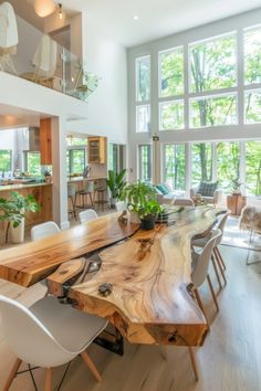 a large wooden table sitting in the middle of a living room with lots of windows