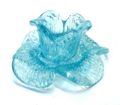 a blue glass vase sitting on top of a white table