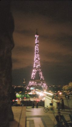 the eiffel tower is lit up at night