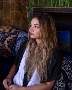 a woman with long hair sitting on a couch