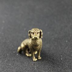 a small golden dog figurine sitting on the ground