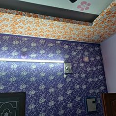 a bathroom with purple and orange wallpaper and floral pattern on the ceiling, along with a light fixture