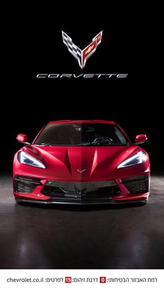 the front end of a red chevrolet sports car in a dark room with corvette logo above it