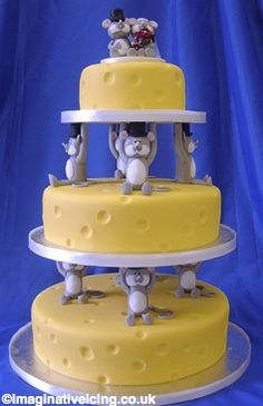 a three tiered cake with teddy bears on the top and bottom layer is yellow