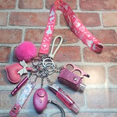 various items are laid out on a brick floor next to a pink keychain