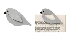 two paper birds sitting next to each other on top of an open book with the pages cut out