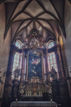 an ornate alter in a church with stained glass windows