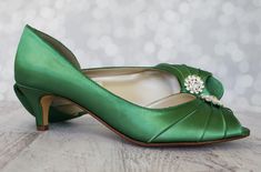 "Make your wedding dress green with envy! These 1 3/4\" bridal peep toes (measured like this: http://www.customweddingshoe.com/how-heel-height-is-measured.html) are shown here in Emerald Green and feature a simple silver crystal brooch on the toe. Color Change: Want this shoe in a different color? We can change the base shoe color for you! To order this shoe in a different color, please send us a CUSTOM REQUEST. To view our catalogue of colors, please visit our website at: https://customweddings Wide Width Wedding Shoes, Low Heel Bridal Shoes, Bridal Shoes Green, Emerald Green Shoes, Low Heel Wedding Shoes, Simple Wedding Shoes, Low Heels Wedding, Wedding Shoes For Bride, Custom Wedding Shoes