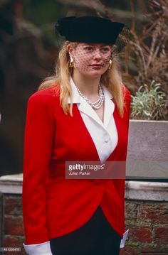 a woman wearing a red jacket and black hat