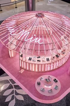 a ferris wheel is lit up with pink lighting