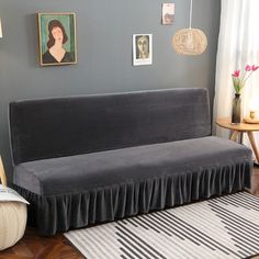 a living room with a gray couch and pictures on the wall