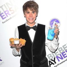 a boy in a tuxedo is holding some food