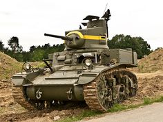 an army tank sitting on the side of a road next to a pile of dirt