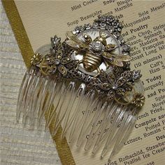 a comb that has been placed on top of an open book with a bee brooch