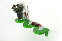 a green shelf with sunglasses and plants on it