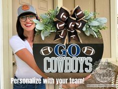 a woman holding up a football sign with the words go cowboys on it and flowers