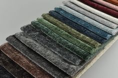 several colors of towels stacked on top of each other in different sizes and shapes, all lined up together