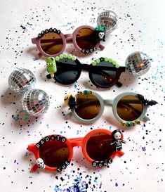 five pairs of sunglasses with different designs on them and some confetti sprinkles