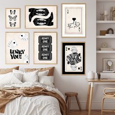 a bedroom with white walls and pictures on the wall