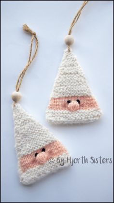 two knitted christmas ornaments hanging from strings