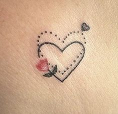 a small heart tattoo on the back of a woman's arm