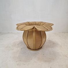 a table made out of wood with leaves on the top and bottom, against a white wall