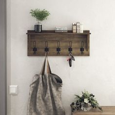 a bag hanging on a wall next to a potted plant and knife holder with hooks