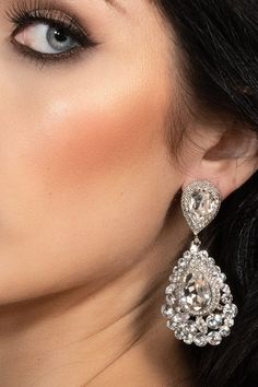 a close up of a woman's face wearing earrings