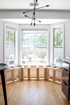 an empty room with several windows and wooden boxes on the floor