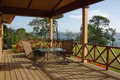 a wooden deck with chairs and table on it