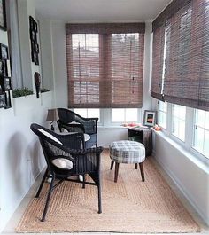 a living room with two chairs and a rug on the floor in front of windows