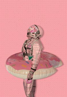 an astronaut is standing on a pink donut