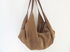 "DeLuna is a large hobo bag designed for women who love to carry slouchy handbags. Featured in this listing in suede leather, in dark brown and camel, it has plenty of room for all your essentials which makes it the perfect carryall bag. The contrast of the two-tone colors on the straps and on the main body is what makes the design unique and stand out. The straps sit comfortably on your shoulder and the bag is secured with a top zipper closure. Inside the bag, there is one main compartment with Soft Leather Hobo Bag, Slouchy Hobo Bag, Leather Hobo Bags, Studded Backpack, Large Hobo Bag, Suede Purse, Soft Leather Bag, Suede Bag, Bags Leather Handbags