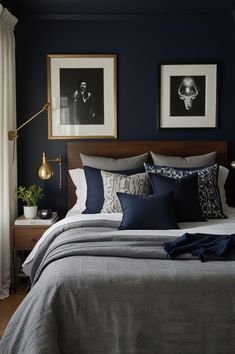 a bedroom with blue walls and pictures on the wall above the bed, along with two lamps