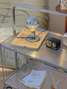 a table with a lamp on top of it next to a book and other items